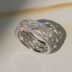 a diamond ring is shown on a white surface with light shining through the top and bottom