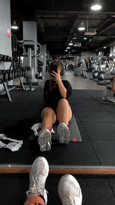 a woman sitting on top of a gym floor