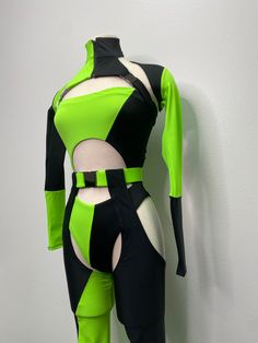 a woman's green and black bodysuit on display in front of a white wall