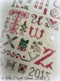 a cross stitch pattern with the letters and numbers in red, white and green on it