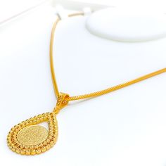 This stunning 22k gold pendant, weighing 7.8 grams, features an intricate engraved design that showcases exceptional craftsmanship. The yellow gold finish highlights the detailed engravings, making it a captivating accessory for any occasion. With a length of 1.75 inches, this pendant balances boldness and elegance perfectly. Ideal for those who appreciate detailed artistry and high-quality gold, this pendant can be paired with any chain of your choice. Its elaborate design and luxurious appeal make it a treasured addition to any jewelry collection, adding a touch of timeless beauty to any outfit. PRODUCT DETAILS Gold Purity(karat): 22k Gold Weight(grams): 7.8 Item Finish: Yellow Gold Pendant Length: 1.75" Chain: Not Included Traditional Gold Plated Coin Pendant Jewelry, Gold Filigree Oval Pendant Necklace, Traditional Yellow Gold Oval Pendant Jewelry, Traditional Coin Pendant Jewelry For Formal Occasions, Traditional Coin Pendant Jewelry For Formal Events, Traditional Gold Coin Jewelry, Traditional Necklace With Large Teardrop Pendant, Gold Filigree Teardrop Pendant Jewelry, 22k Gold Engraved Ceremonial Necklace