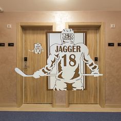 an image of a hockey player in front of the locker room door with his sticker on it