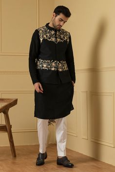 Black semi raw silk bundi with mandarin collar, floral jaal pattern peach threads and silver zari hand embroidery. Paired with full sleeves kurta and contrast trousers.
Components: 3
Pattern: Hand Embroidered
Type Of Work: Resham and Sequin Work
Neckline: Mandarin Collar
Sleeve Type: Bundi: Sleeveless, Kurta: Full Sleeves
Fabric: Semi Raw Silk
Color: Black
Other Details: 
Placement embroidery
Bundi Closure: Front concealed placket
Occasion: Sangeet,Reception - Aza Fashions Types Of Silk Fabric, Sleeveless Kurta, Placement Embroidery, Black Kurta, Floral Work, Men's Ethnic Wear, Diwali Sale, Nehru Jacket, Nehru Jackets