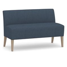 a blue couch sitting on top of a white floor next to a wooden leg chair