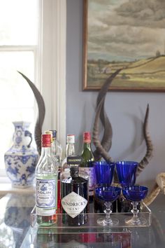 an assortment of liquor bottles and glasses on a glass table