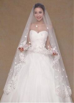 a woman in a white wedding gown and veil