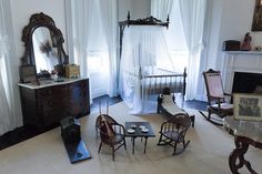 a living room filled with furniture and a fire place next to a window covered in curtains