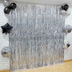 the room is decorated with black and silver balloons, streamers, and disco balls