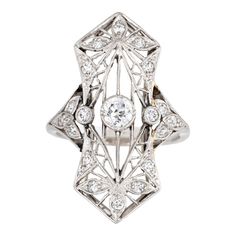 Finely detailed antique Edwardian ring (circa 1900s to 1910s) crafted in 900 platinum.   Centrally mounted estimated 0.25 carat old Mine cut diamond is accented with 18 x estimated 0.02 to 0.03 carat diamonds. The total diamond weight is estimated at 0.63 carats. The diamonds are estimated at H-I colour and SI1-2 clarity.   The ring features lacy filigree detail within an elongated shield mount, a hallmark of the Edwardian era. With a slight curved saddle the ring sits comfortably on the finger Edwardian Diamond Ring, Diamond Ring Platinum, Edwardian Ring, Antique Jewelry Rings, Old Mine Cut Diamond, Vintage Fine Jewelry, Antique Ring, Edwardian Era, Diamond Cluster Ring