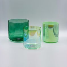 three different colored glass vases sitting next to each other