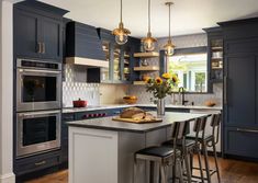 a kitchen with blue cabinets and stainless steel appliances