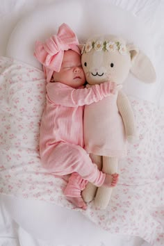 a baby sleeping next to a stuffed animal