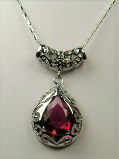 Simulated Red Ruby PendantBig Teardrop Design#P28This is a stunning Victorian inspired pendant necklace. This beautiful necklace is handcrafted from sterling silver. The flawless 6 carat man-made red ruby is a pear cut gemstone. Measurements are 16mm in length and 12mm in width. The 1.5mm sterling silver chain is 18" long (Chain may be different than pictured). The entire pendant is 1-11/16" long by 13/16" wide. The pendant & necklace are marked 925 for sterling silver. Notice the beautiful craf Exquisite Silver Teardrop Pendant Necklace, Elegant Pear-shaped Ruby Jewelry, Formal Pear-shaped Ruby Necklace, Fine Jewelry Ruby Necklace In Pear Shape, Elegant Ruby Teardrop Pendant Necklace, Formal Ruby Drop Necklace, Formal Drop Ruby Necklaces, Formal Pear-shaped Ruby Jewelry, Fine Jewelry Ruby Drop Necklace