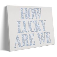 a white canvas with the words how lucky are we? printed in blue on it