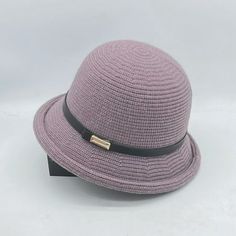 a purple hat with a black ribbon around the brim and gold buckle on it