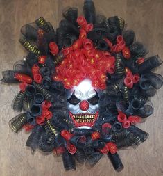 a skull with red hair and makeup surrounded by black plastic bottles on a wooden floor