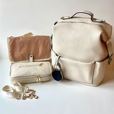 two white purses sitting next to each other on top of a table with shoes