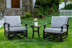 two chairs and a table in the grass