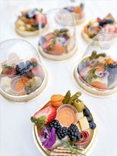 several plates with different types of food on them sitting on a white tablecloth covered table