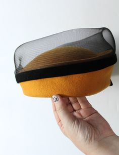 Here we have an awesome Vintage 100% Wool Yellow Tea Party - Church - Dress Hat from the 1960s, possibly older and it was made in the USA. It is in great shape with minimal wear. The top of the hat has a black mesh and there is a black velvet bow around the entire hat. In the front on the bow there is a yellow and gold decorative brooch like accent. It measures roughly 11 inches in diameter, 6 inches in height in the front and the head hole is 7 inches in diameter. Great accessory to add to any Retro Fitted Hat For Church, Retro Fitted Church Hats, Fitted Retro Hats For Vintage Events, Retro Fitted Hats For Vintage Events, Yellow Tea Party, Dressy Hats, Black Velvet Bow, Yellow Tea, Church Dress