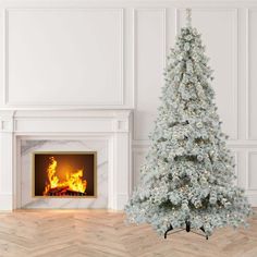 a white christmas tree sitting in front of a fireplace