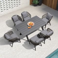 an outdoor dining table with six chairs and a plate of fruit on it next to a swimming pool