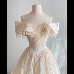 a white dress on a mannequin dummy with lace detailing and off the shoulder sleeves