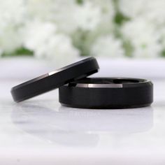 two black wedding bands sitting next to each other