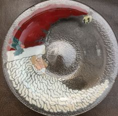 a glass plate with a santa hat on it and other decorations around the rims