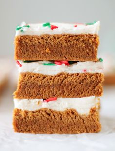 three pieces of cake with white frosting and candy canes on top are stacked up