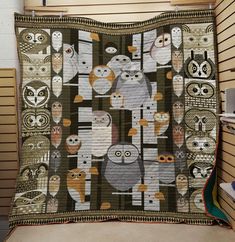 an owl themed quilt hanging on a wall