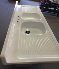 a white sink sitting on top of a counter in a room next to other items