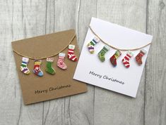 two christmas cards with stockings hanging from them