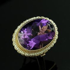 Amethyst Ring Victorian Style Cocktail Large Oval Seed Pearls Yellow Gold Bezel Set Gemstone There is nothing subtle and delicate about this ring. Flashy, expensive looking ring made of 14K yellow gold with a luxurious looking, large, oval amethyst (approximately 12ct) set in bezel and surrounded by a halo of gold twisted wire and oriental seed pearls. Sizes: 4-8 (smaller and larger sizes are available as custom orders.) PROUDLY MADE FROM SCRATCH IN NEW YORK CITY. Please allow 2-3 weeks to compl Formal Multi-stone Oval Amethyst Ring, Formal Oval Amethyst Multi-stone Ring, Oval Multi-stone Amethyst Ring For Formal Occasions, Formal Oval Amethyst Ring With Multiple Stones, Elegant Amethyst Oval Cabochon Ring, Luxury Oval Pearl Ring With Center Stone, Elegant Oval Multi-stone Amethyst Ring, Elegant Oval Cabochon Amethyst Rings, Oval Amethyst Multi-stone Ring In Yellow Gold