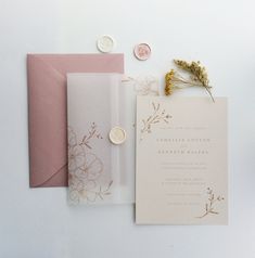 the wedding stationery is laid out on top of each other with buttons and wax