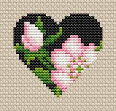 a cross stitch heart with pink flowers in the center and green leaves on it's side