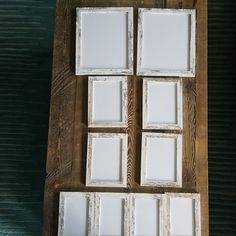 six white frames sitting on top of a wooden table