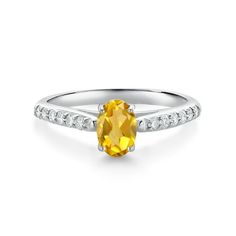 a yellow sapphire and diamond ring with white diamonds on the sides, set in 18k white gold