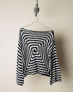 a black and white sweater hanging on a hook