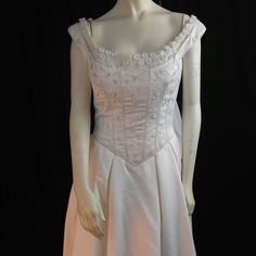 a mannequin dressed in a white dress on display