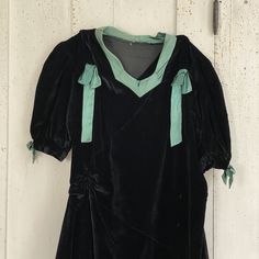 Hello and Welcome to the Textile Trunk! Please follow us on Instagram we are @textiletrunk I date it to around the 1920-1940? or perhaps a bit earlier. I love the cheeky look of only one long sleeve! Made of black velvet with green satin collar and bows ~ I LOVE the ruched waist!! ~ ( Dress E 8R) MEASUREMENTS : This gorgeous Vintage French dress measures : 57 inches long 15 inches across the shoulders 33 inch waist 38 inches around the chest CONDITION : This lovely dress is in as found, not fres Fitted Vintage Victorian Dress For Theater, Retro Long Sleeve Vintage Dress For Costume, Retro Long Sleeve Vintage Costume Dress, Black Vintage Dress For Costume Party, Black Vintage Dress For Costume, Black Vintage Victorian Dress, 1920s Fitted Costume Dress, Vintage Long Sleeve Dress For Costume Party, Vintage Long Sleeve Theater Dress