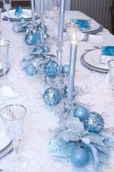 the table is set with silver and blue decorations