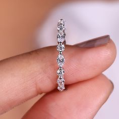 a woman's hand holding a diamond ring with three stones on the inside of it