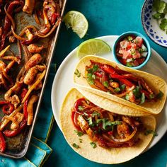 three tacos are on a plate next to a tray of guacamole