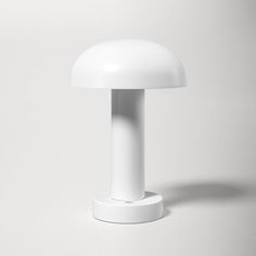 a white table lamp sitting on top of a white surface