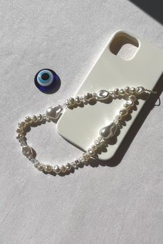 a cell phone with a chain attached to it and a blue eye on the back