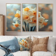 three pictures of daffodils on a wall above a white couch in a living room