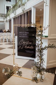 a sign that is in the middle of a room with chairs and plants on it