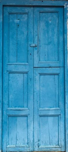 an old blue door is open on a building