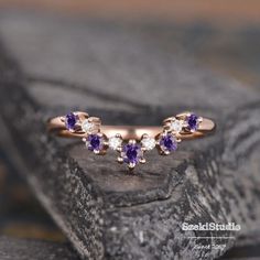 three amethyst purple and white stones in an 18k rose gold ring